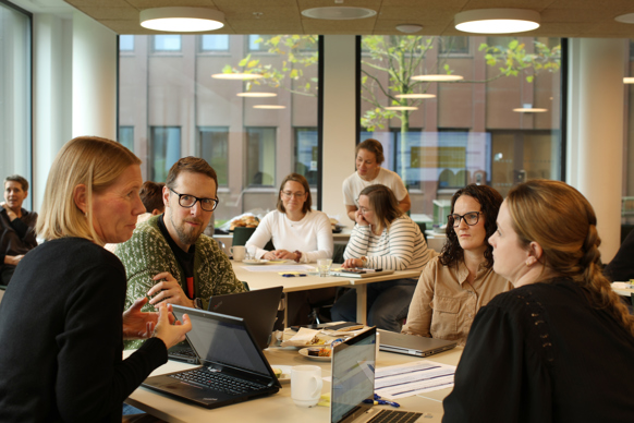 Arve Ubøe Rohde sitter sammen med flere deltakere rundt bordet og diskuterer.