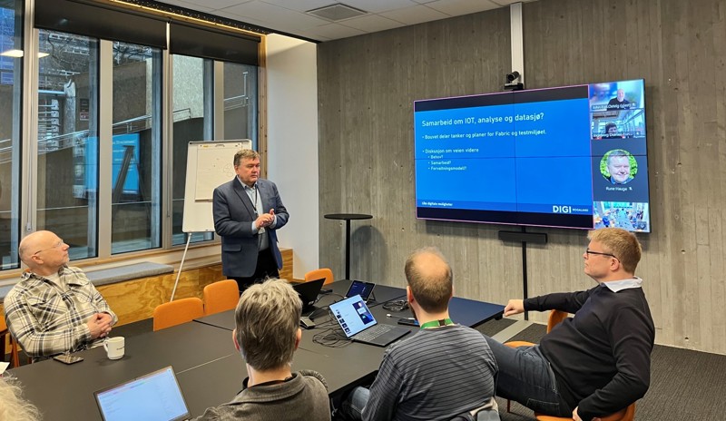 Vi ser Rune Hauge som snakker i møterommet foran skjermen til de fremmøtte.