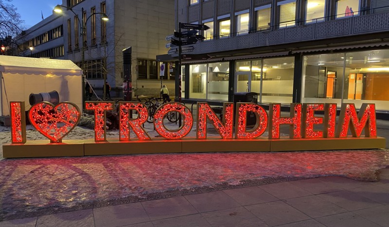 Bildet viser et rødt lyskilt uten for helsehuset hvor det står Trondheim på.
