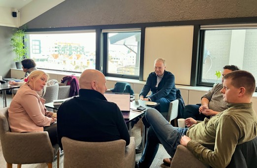 Bildet viser et bort med deltakere som prater sammen.